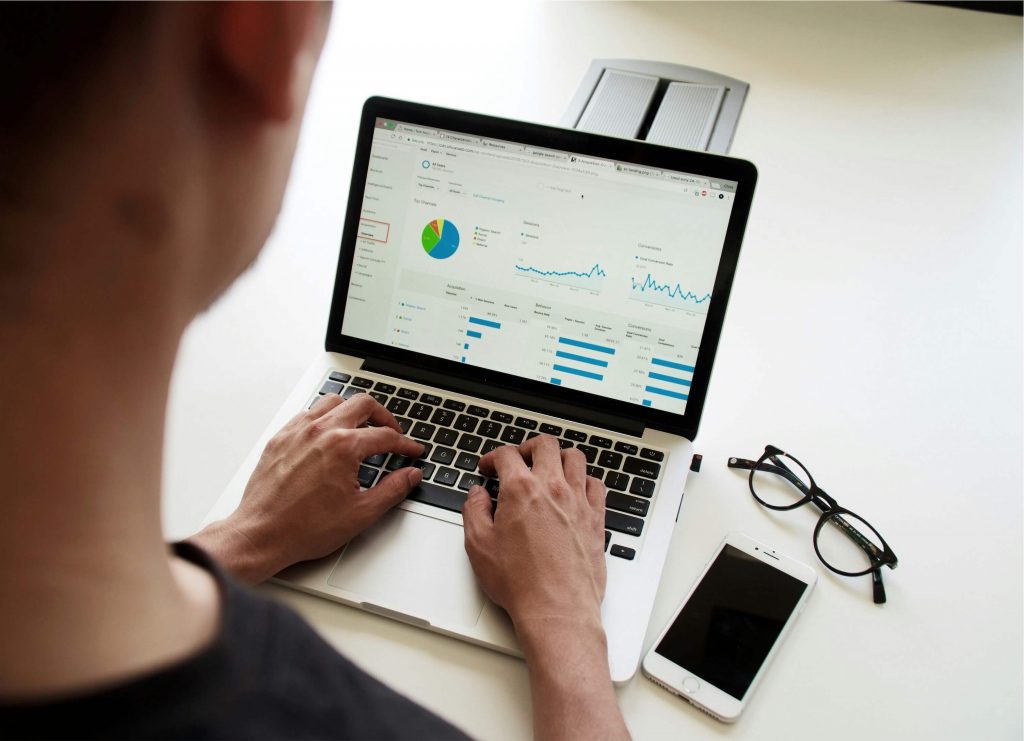 A person looking at metrics displayed on a MacBook.
